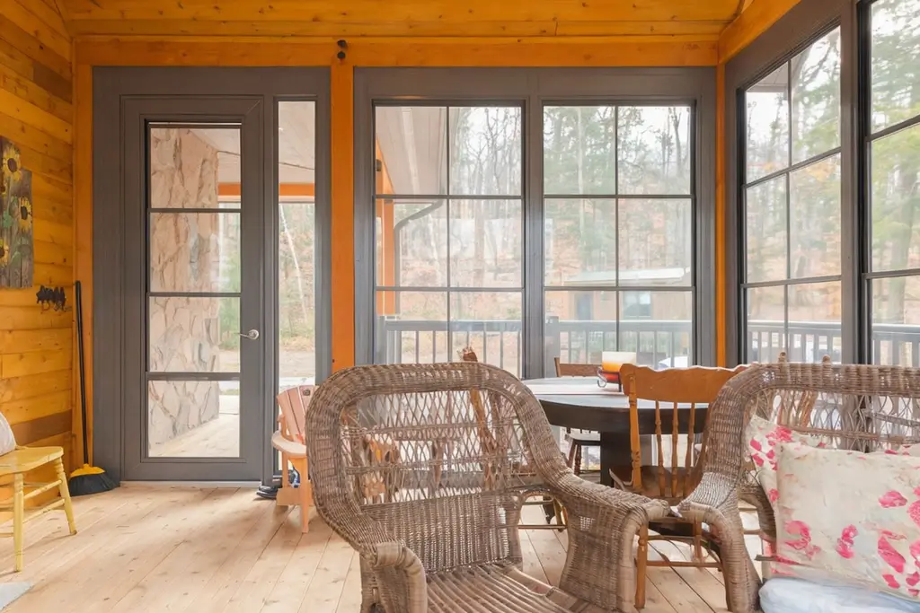 A cozy Sunroom featuring wicker chairs and a table, enhanced by WeatherMaster™ Doors for a bright, inviting atmosphere.