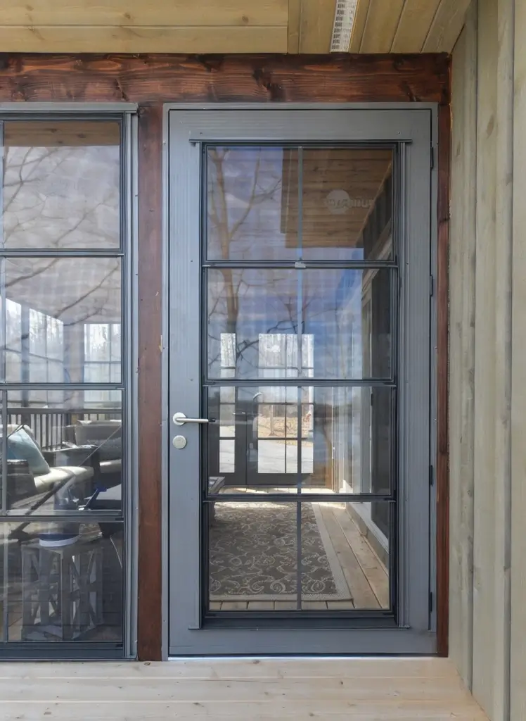 A wooden deck featuring a glass door and a table, showcasing WeatherMaster™ Doors for enhanced outdoor living.