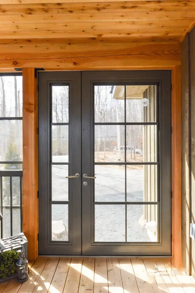 A wooden porch featuring a WeatherMaster™ Door and a single chair, inviting and cozy in appearance.