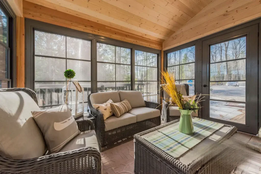 A Sunroom featuring wicker furniture and large windows, showcasing WeatherMaster™ Doors for enhanced natural light.