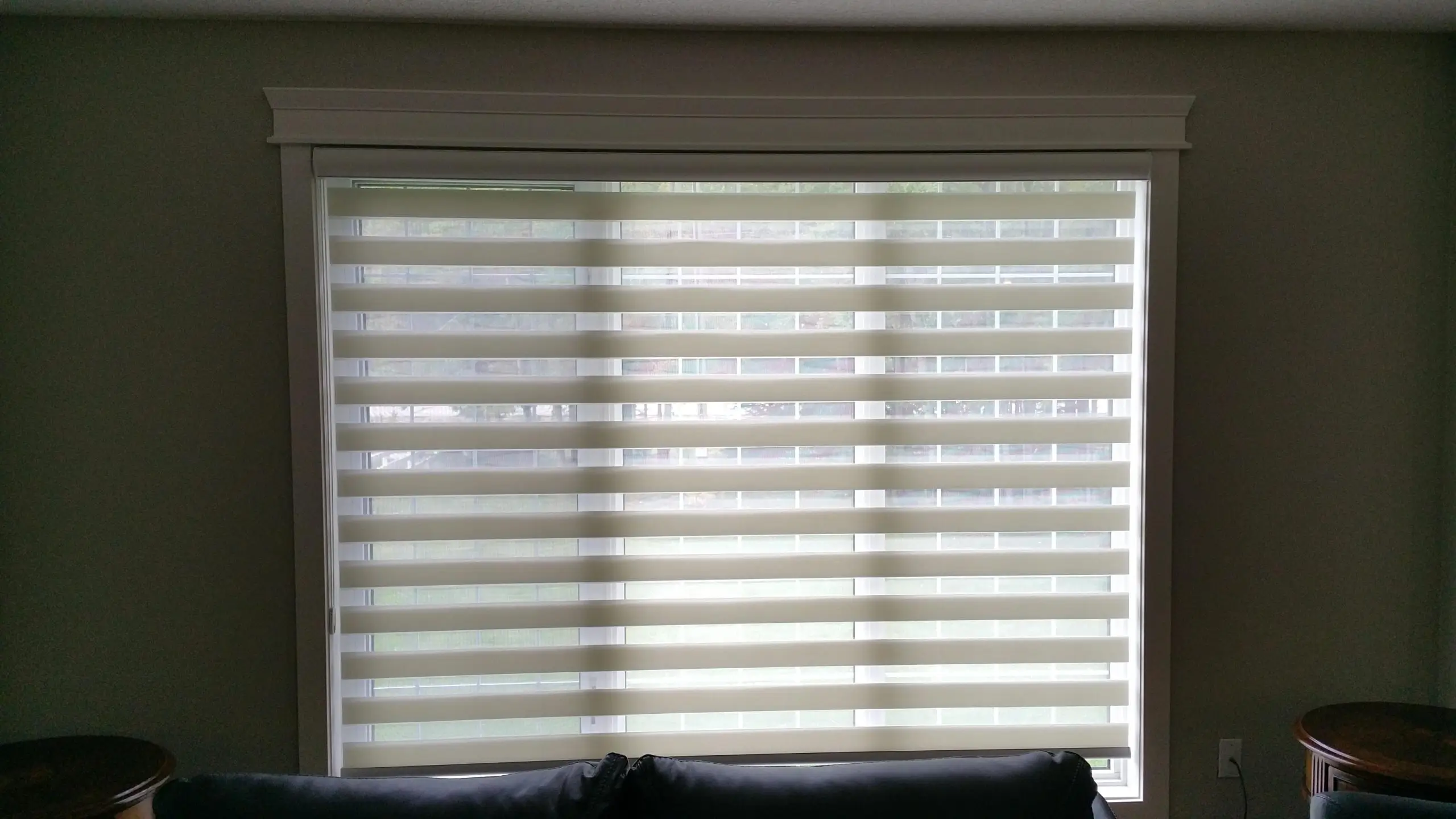 A couch in front of a window adorned with Vertican blinds, enhancing the room's comfort and style.