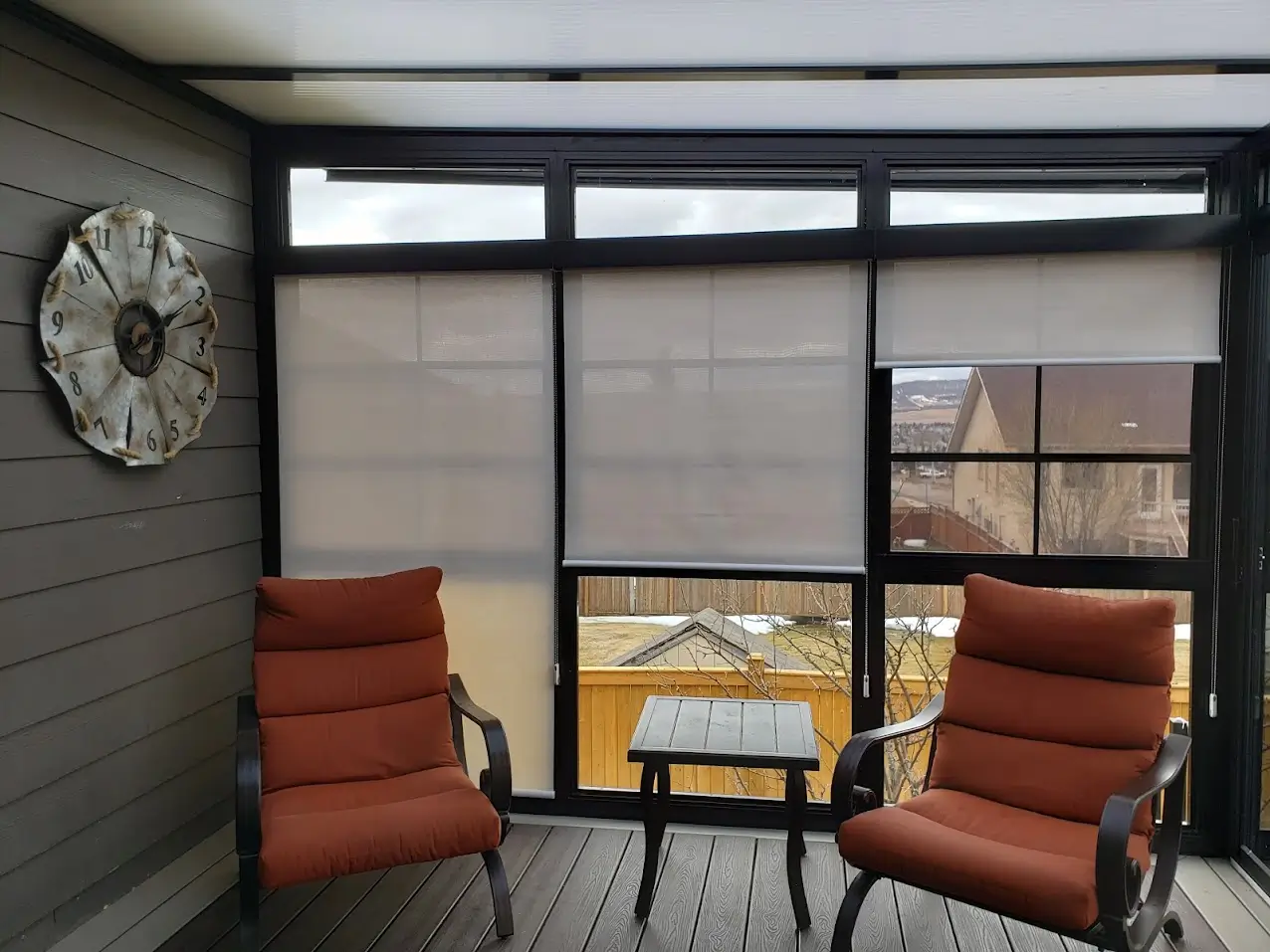 A deck features two chairs and Roll Shutters, providing a view of the bustling city below.