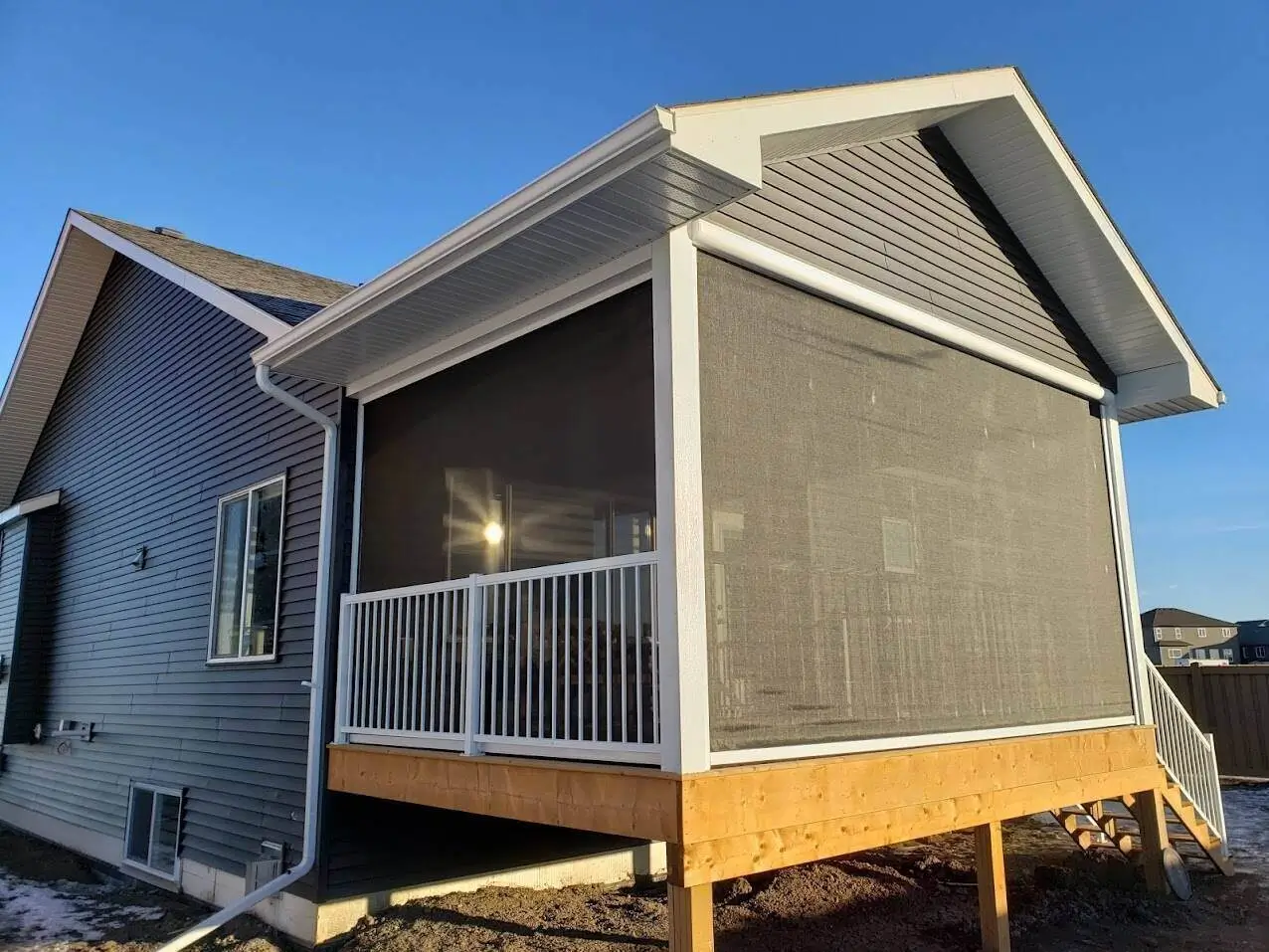 A residence showcasing a screened porch with integrated railings and a deck, ideal for enjoying the outdoors.