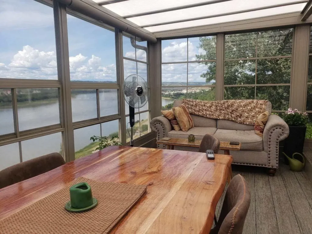 Bright sunroom with a table and chairs, showcasing a picturesque view of the river.