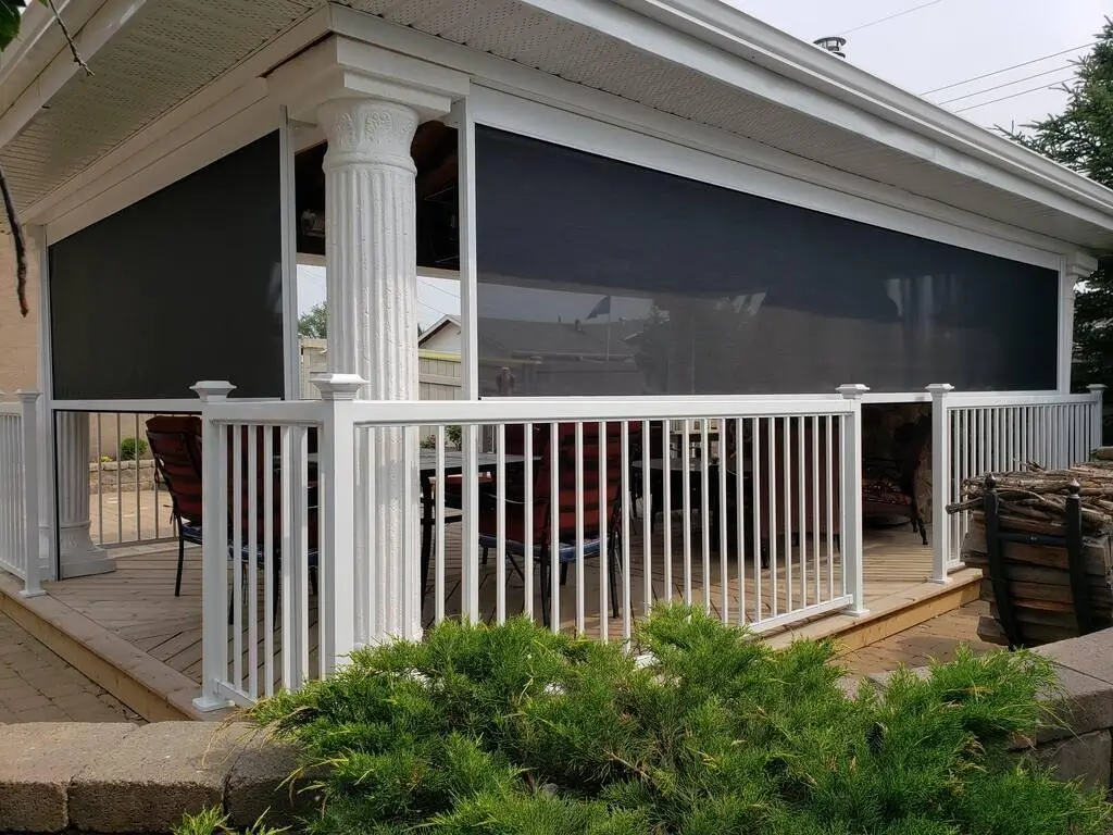 A cozy screened porch featuring a table and chairs, perfect for enjoying the outdoors with Habitat Screens.