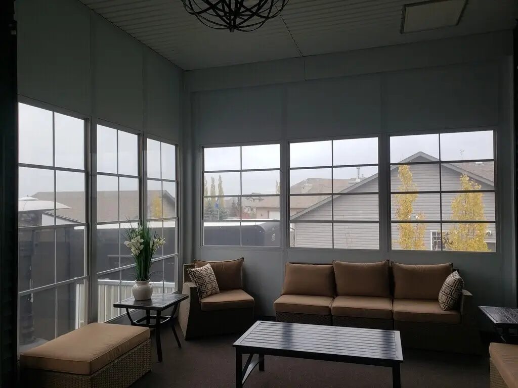 Bright Sunroom with cozy couches and a table, showcasing the clarity of WeatherMaster™ Windows.