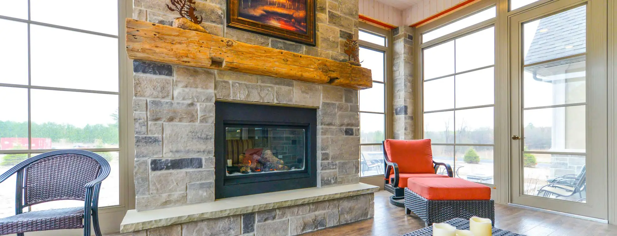 A living room with a warm fireplace and expansive windows, highlighting the elegant WeatherMaster™ Doors design.